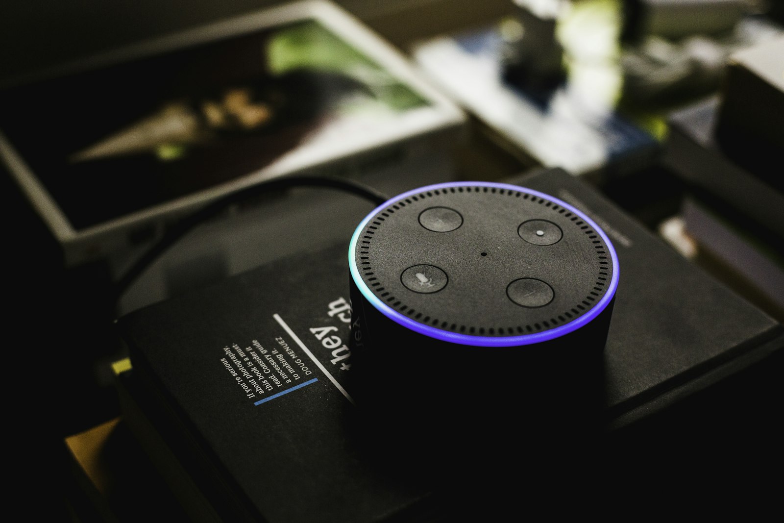 A voice-enabled smart speaker on a shelf in a home setting.